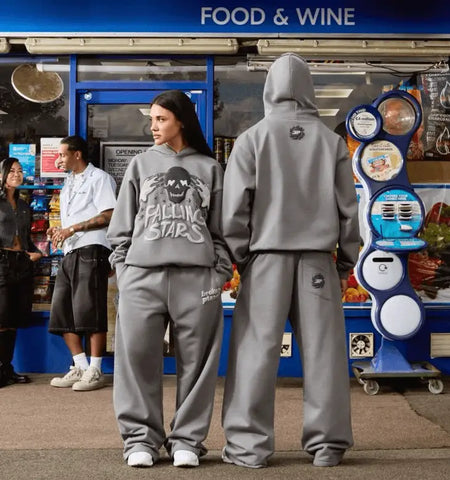 Three people at a food and wine vendor stall in oversized hoodies showcasing Y2K style.