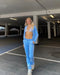 Person in blue tracksuit and white crop top modeling stylish velour sweat outfits