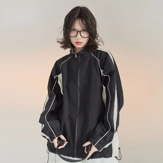 Woman in a black zip-up Vintage Windbreaker Jacket with round glasses, showcasing Y2K style