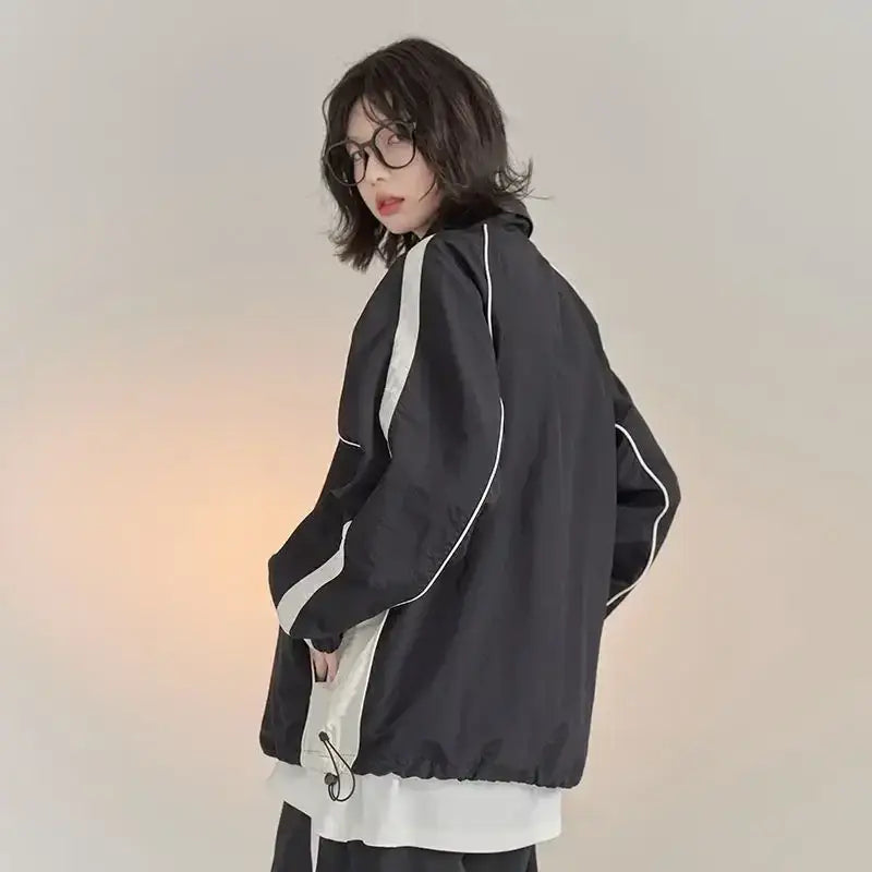 Dark vintage windbreaker jacket with white trim over a light-colored shirt