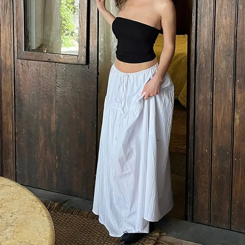 Woman in a black strapless top paired with a stylish white maxi skirt