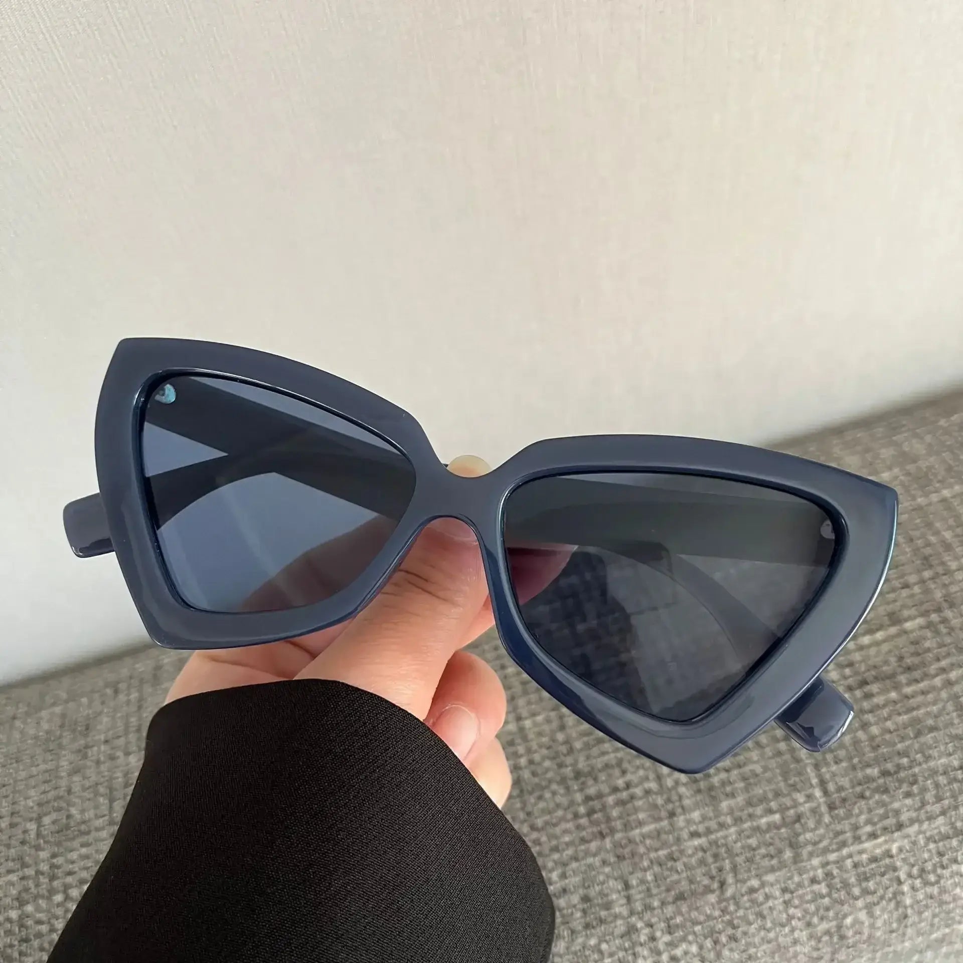 Cat eye sunglasses featuring triangular-shaped black frames for women