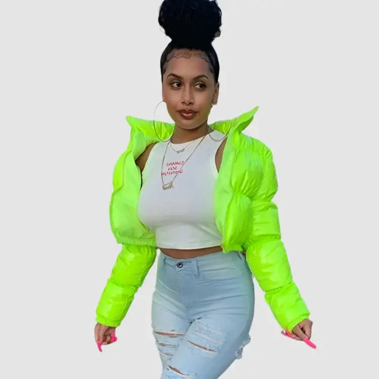 Woman in neon green Y2K cropped jacket, white crop top, and ripped light blue jeans