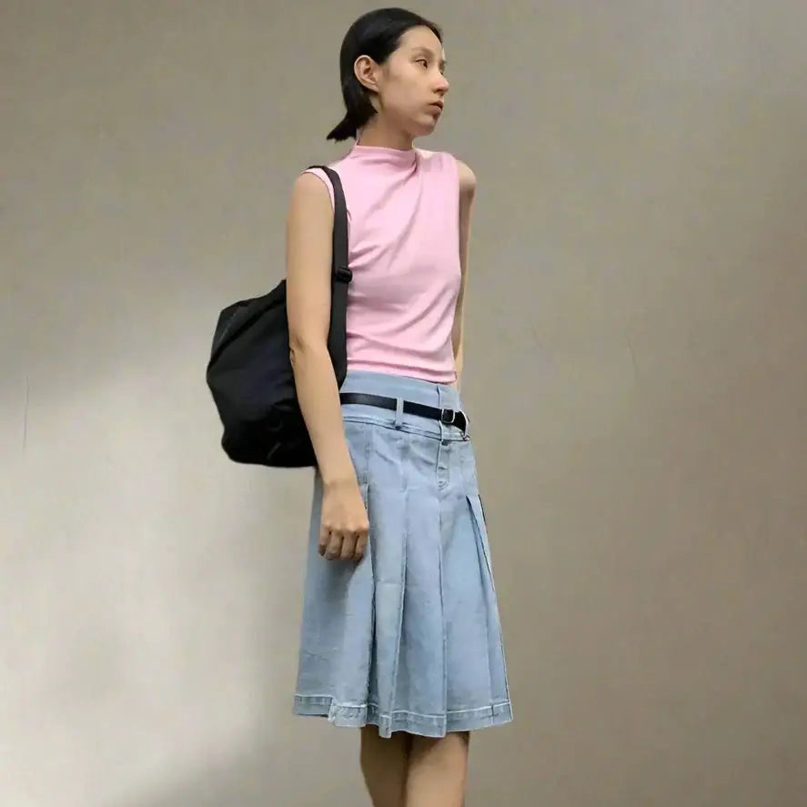 Woman in a pink sleeveless top and denim skirt from the Y2K Denim collection