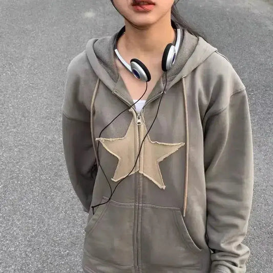 Gray Y2K embroided hoodie with beige star design and headphones around neck