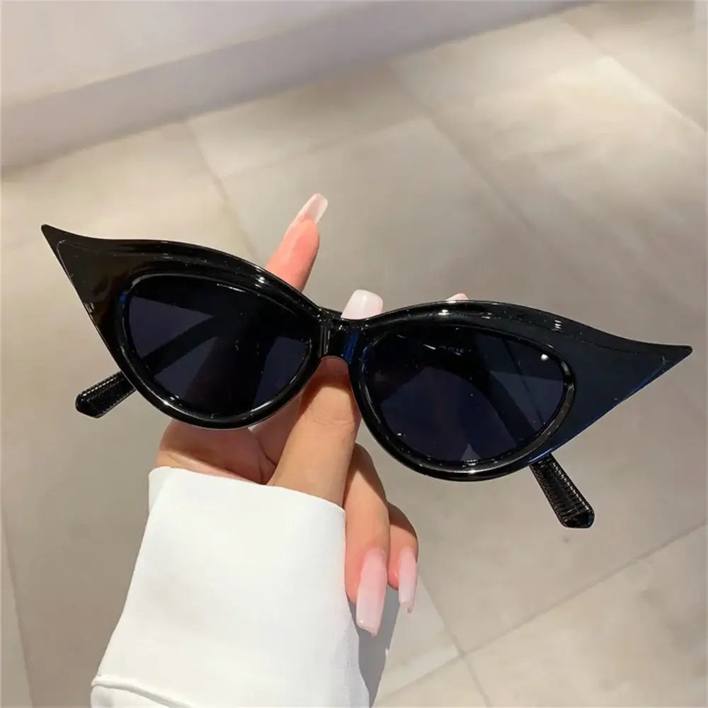 Cat-eye sunglasses with dark lenses and glossy black frame for Y2K fashion sunglasses