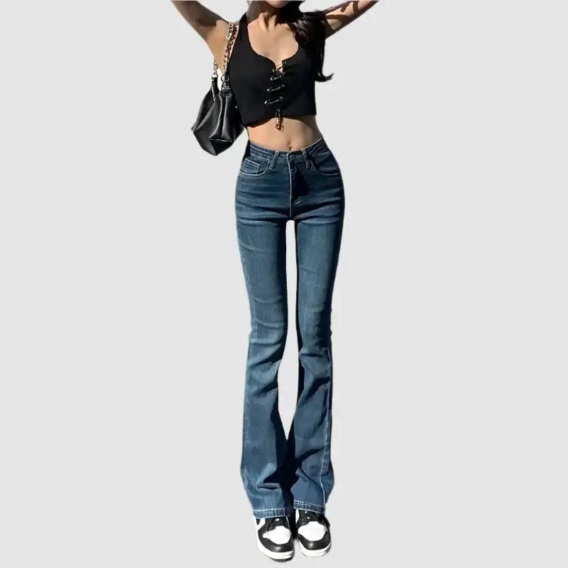 Pair of Y2K flare jeans styled with a cropped black top and trendy sneakers