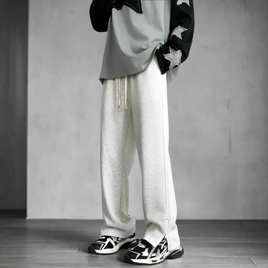 White loose-fitting Y2K flare pants with drawstring waist over black and white sneakers