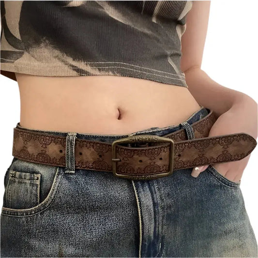 Y2K leather belt with patterned brown strap and metal buckle worn on jeans