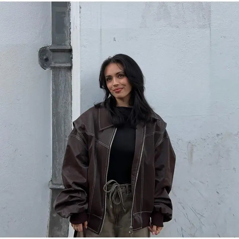 Woman in a brown oversized Y2K leather jacket styled with a dark top