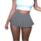 Gray pleated mini skirt paired with a white crop top in Y2K mini fashion