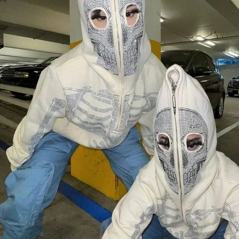 Two people in Y2K Skull Hoodies with mesh face coverings in a parking garage