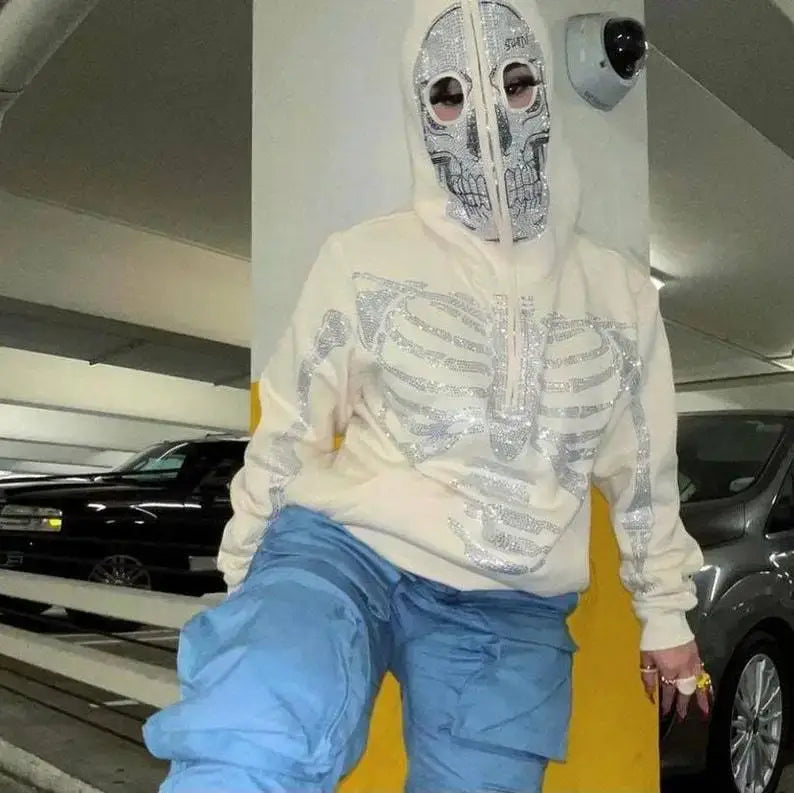 Person in a Y2K Skull Hoodie and mask poses in a parking garage