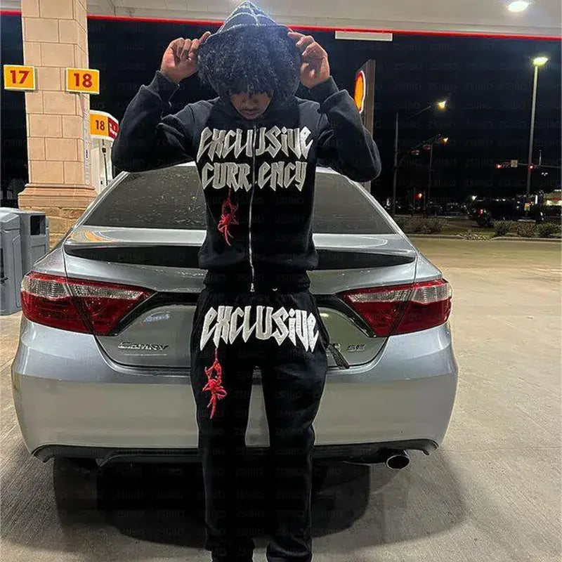 Person in a black Y2K Spider Hoodie and sweatpants poses in front of a car