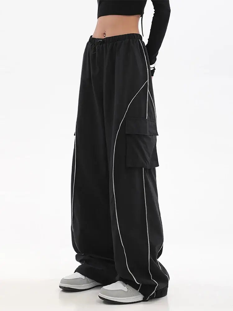 Black Y2K Track Pants featuring wide legs, white piping, and tiered layers