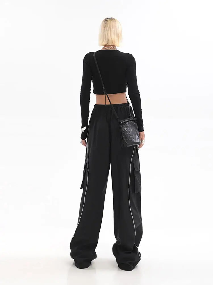 Woman in black crop top and wide-leg Y2K track pants viewed from behind